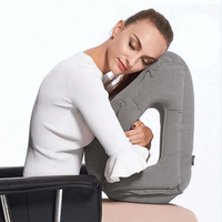 Coussin de voyage gonflable multi-positions utilisé par une femme assise que l'enlace dans ses bras et repose sa tête dessus les yeux fermés