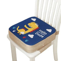 Coussin rehausseur chaise dinosaure  jaune sur le coussin sur un fond bleu avec marqué hello dude, le coussin étant posé sur une chaise blanche et le fond de l'image est blanc