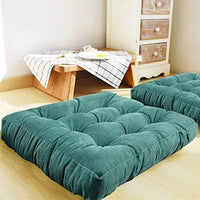 Coussin de sol capitonné turquoise posé au sol un table basse est en arrière plan