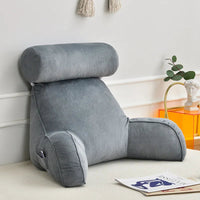 Coussin de lecture en velours gris positionné contre un mur au sol