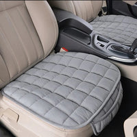 Coussin de voiture pour assise de siège avec poche gris installé sur les deux sièges avant beige d'une voiture