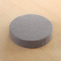 Coussin de yaga gris en lin posé sur un tapis