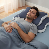 Un homme dormant paisiblement sur le dos avec un oreiller ergonomique à mémoire de forme pour une bonne posture cervicale.