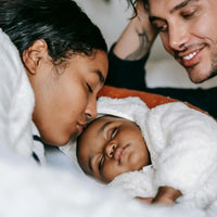 Famille heureuse avec bébé endormi, moment de tendresse et de complicité.