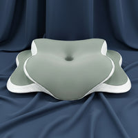 Coussin ergonomique anti-ronflement Ergomax 2 gris-vert en mousse à mémoire de forme sur un tissu bleu foncé.