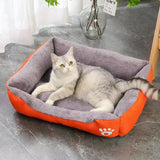 coussin pour chat en forme de rectangle avec des bord surélevé gris à l'intérieur et orange à l'exterieur un chat est allongé dedans 