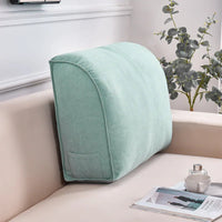 Coussin de canapé pour le dossier d'un canapé beige. Le coussin est de couleur vert avec une poche sur le coté