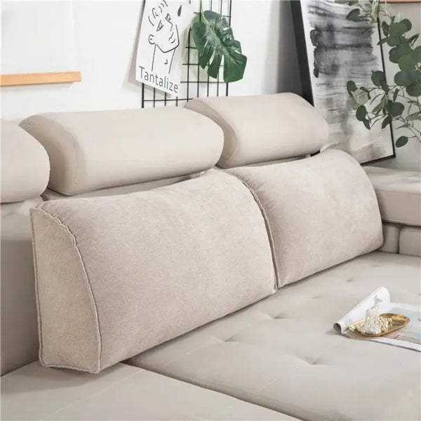 Coussin canapé triangulaire beige qui sont posé sur le dossier d'un canapé