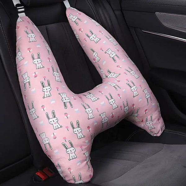 Coussin de voyage lapin pour enfant rose  installé sur le siège arrière d'une voiture