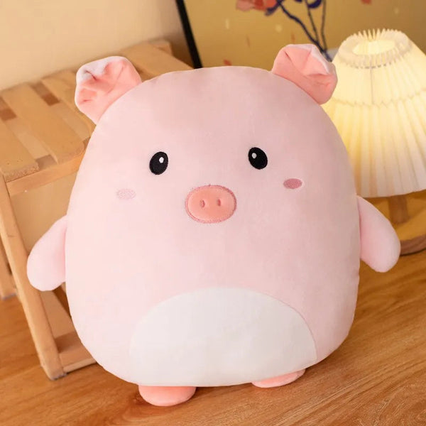 Coussin en forme de rond qui represente un cochon rose tout doux. Il est debout poser contre un tabouret en bois et une lampe de chevet est aussi derrière lui